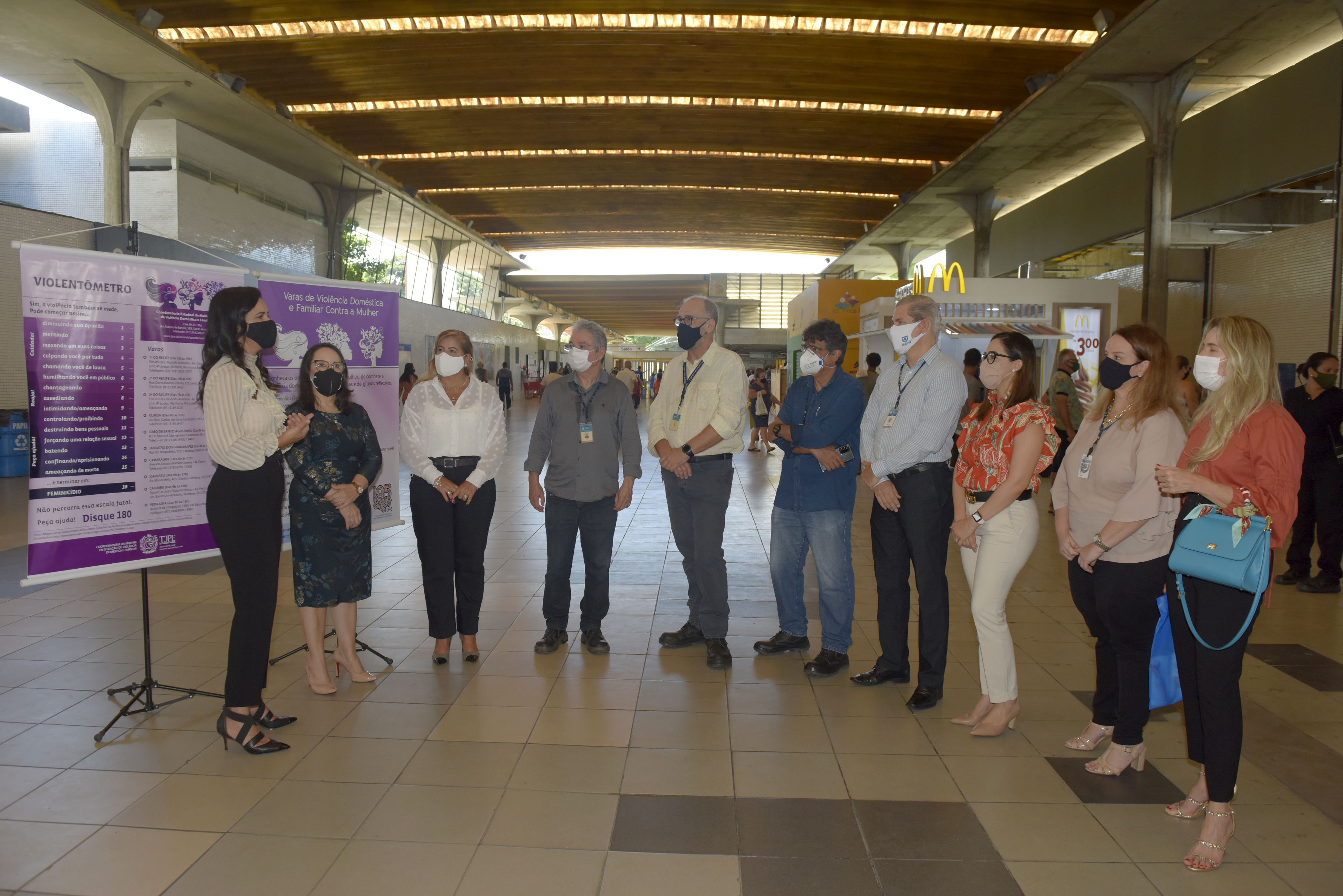 Pessoas reunidas, de pé, no hall de entrada da estação do metrô