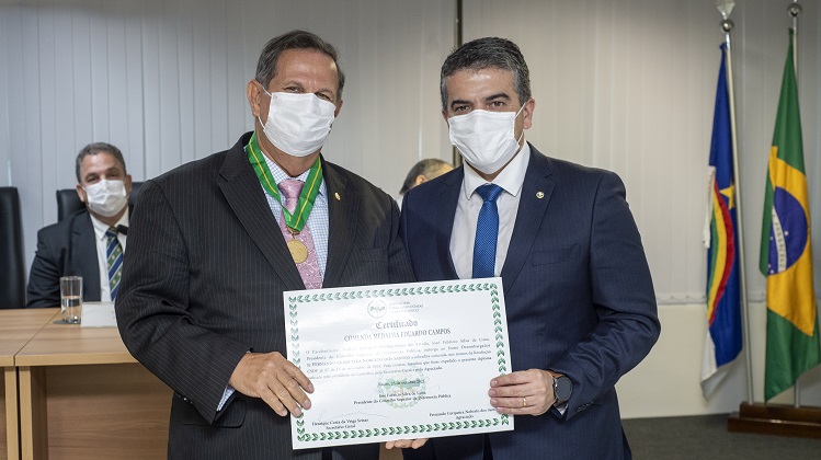 Dois homens lado a lado segurando um diploma