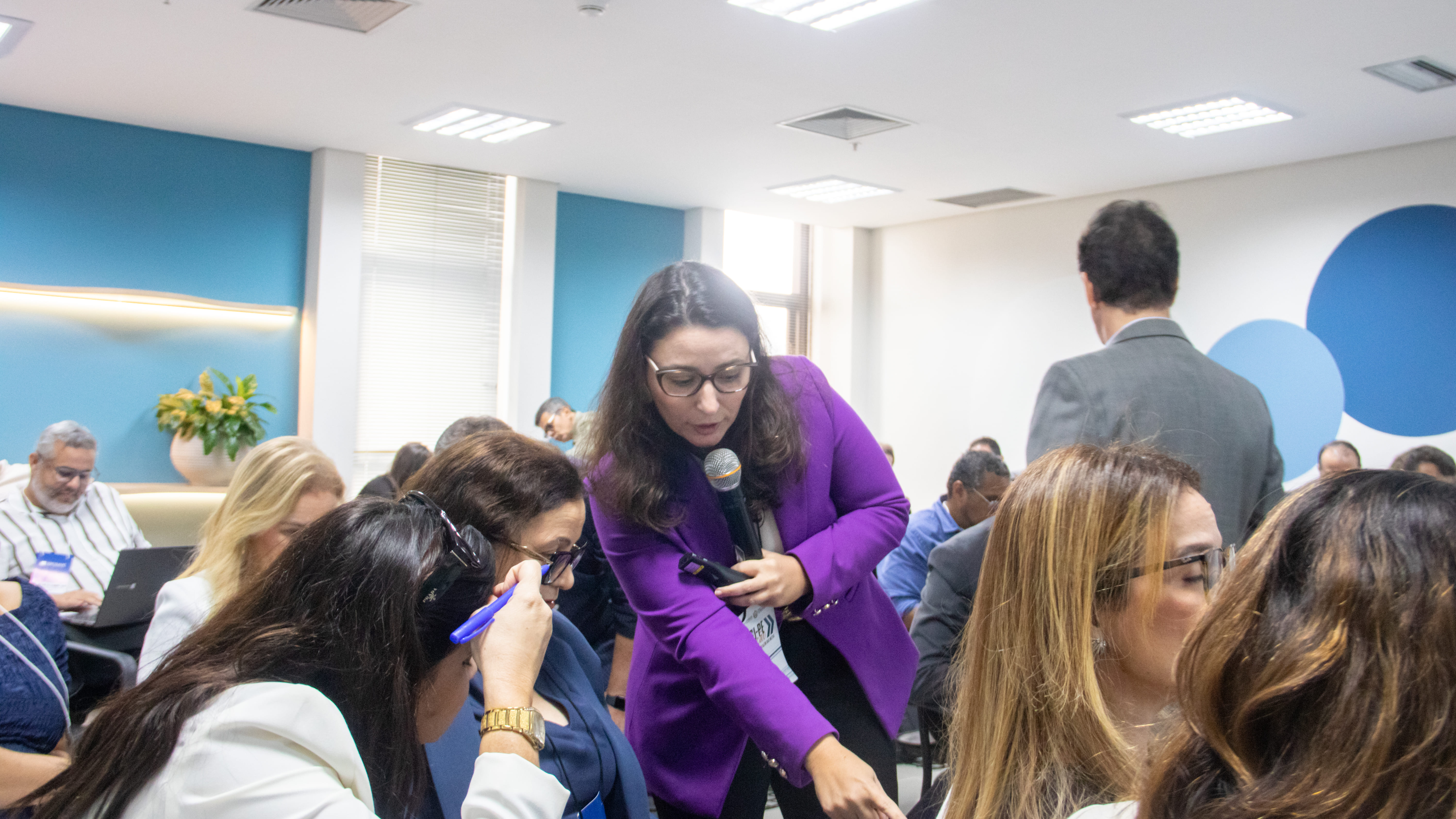 juíza ajudando participantes da capacitação para resolverem na prática