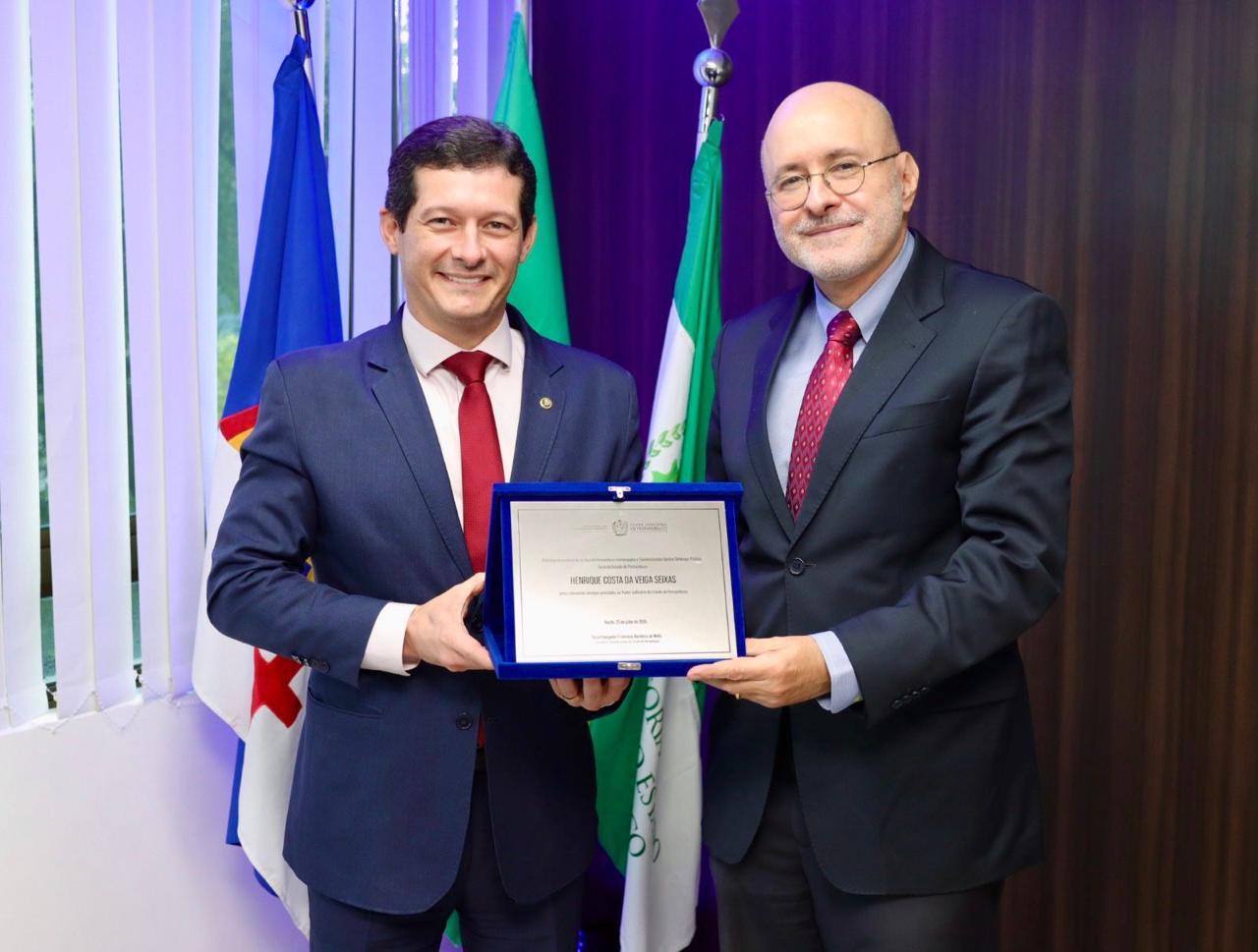 Corregedor entregando a placa de homenagem ao defensor geral