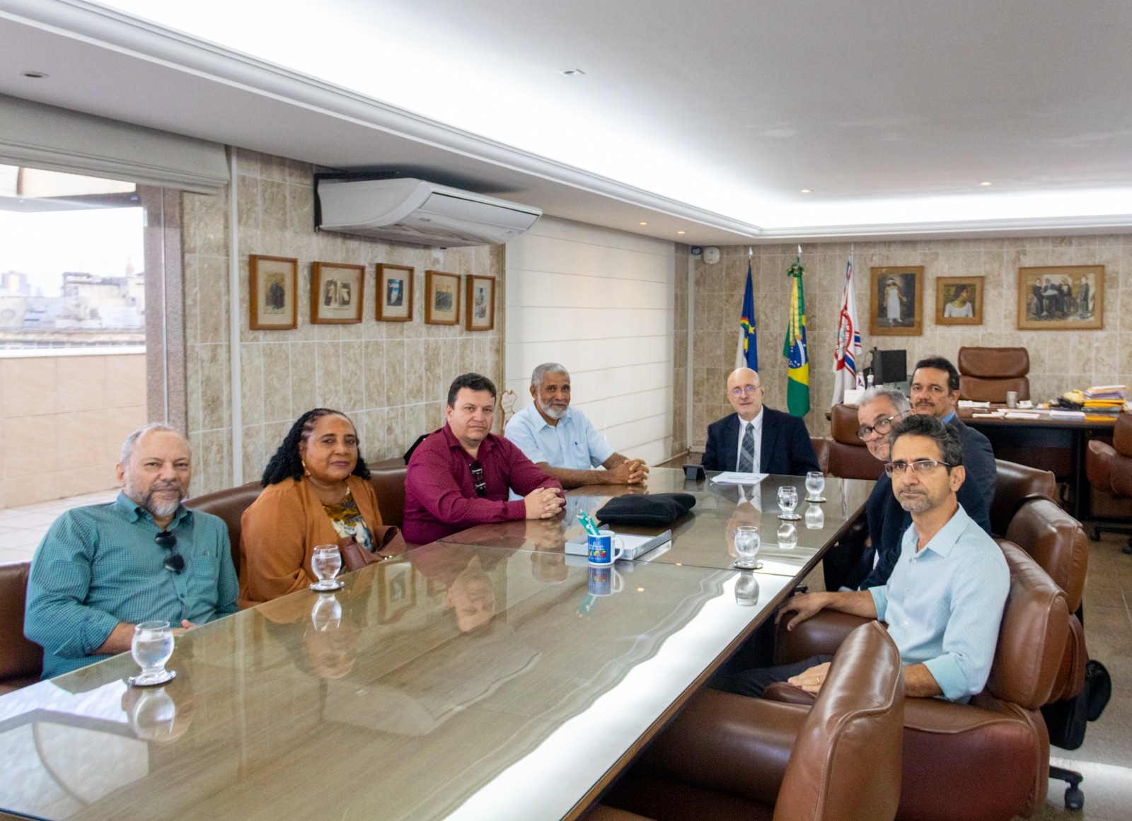 Corregedor sentado na cabeceira de sua mesa no gabinete, com membros da ASPJ-PE ao redor