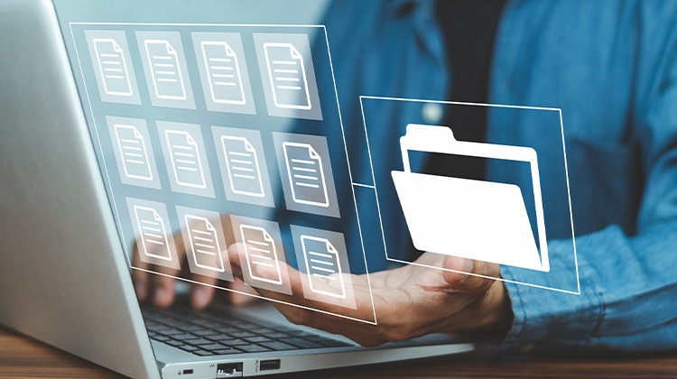 Mãos digitando em um laptop enquanto flutuam ícones de documentos