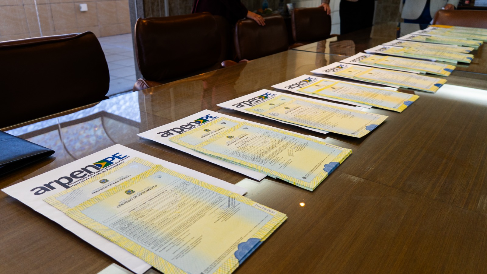 Certidões dispostas em pilhas em uma mesa longa