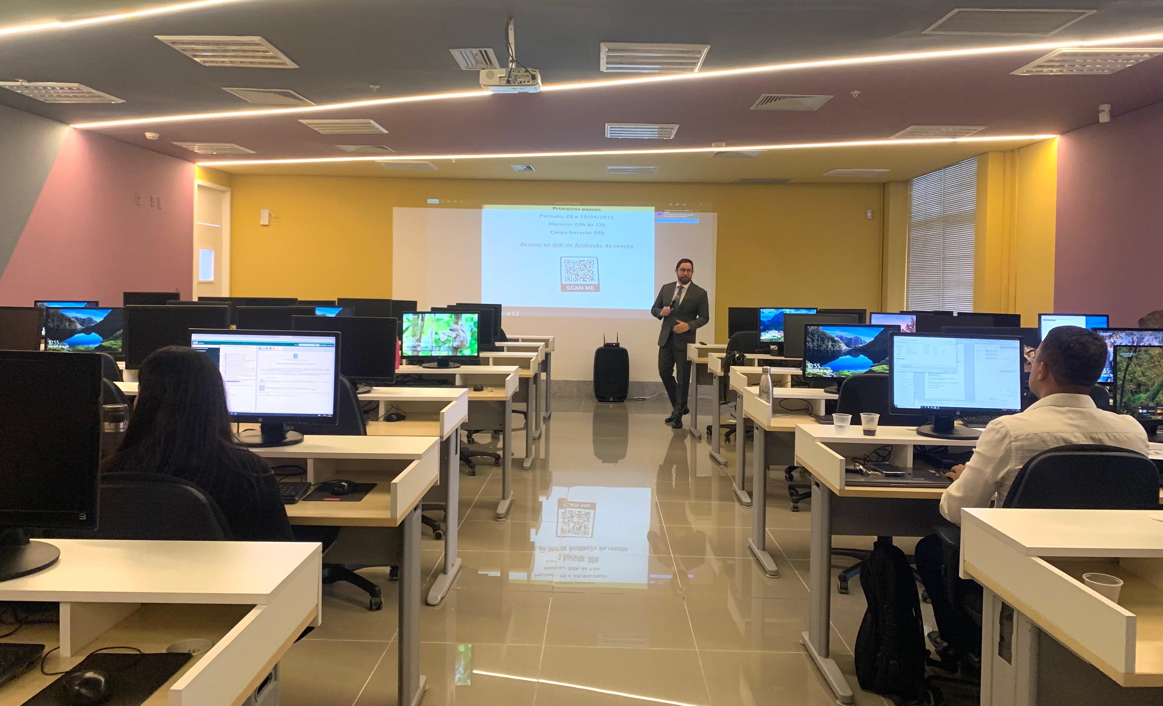 Sala de aula na Esmape. Na imagem aparecem os alunos e o professor, além de computadores. 