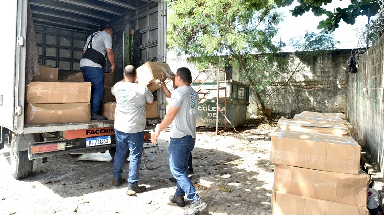 Colaboradores tirando as caixas de papelão do caminhão