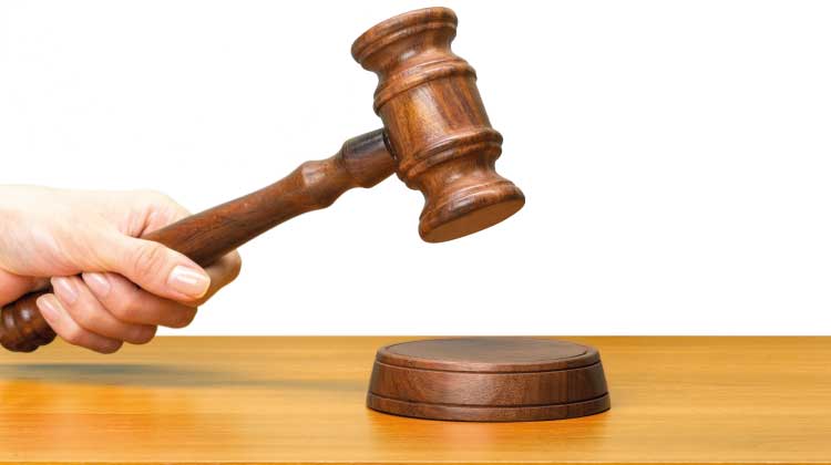 Foto da mão de uma pessoa segurando um martelo judicial